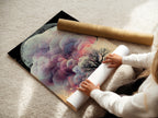 This image shows a woman carefully rolling a fine art poster paper. The poster features a surreal landscape artwork. It includes an ethereal tree. The process highlights the care and quality of fine art printing. Ideal for homeowners and designers seeking unique artwork for modern spaces. Perfect art for meditation.