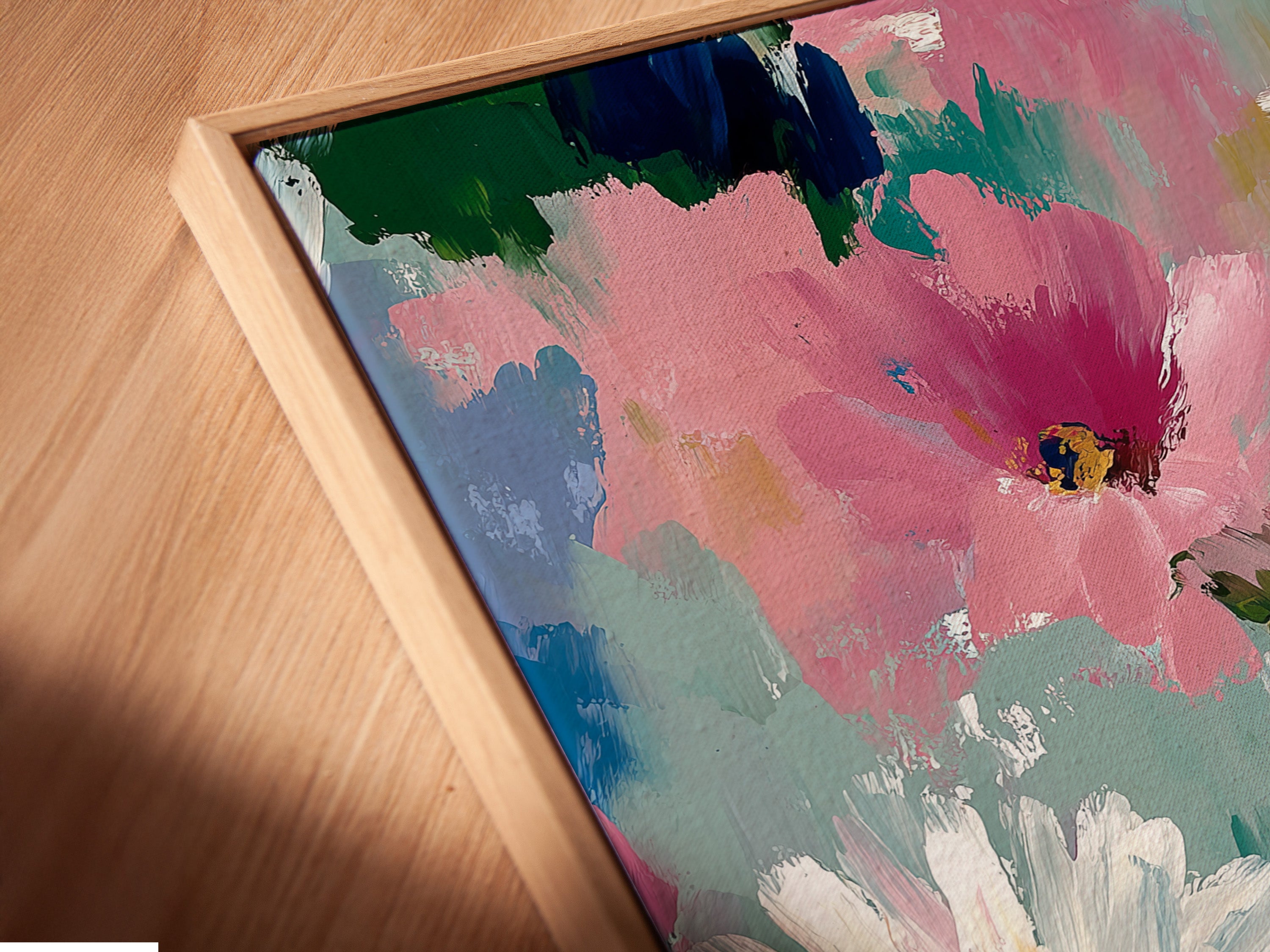 A close-up view of a canvas print in a floating frame. This abstract floral art features pink and white daisies. The floating frame adds depth and sophistication. Perfect for a modern botanical look in any room. This art is ideal for showcasing colorful flower art.