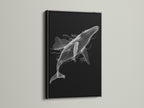 Displayed is a black and white whale artwork in a sleek black frame. This minimalist ocean canvas print offers a bold statement. Perfect for creating a modern and sophisticated space. The black frame adds contrast to the whale artwork. Enhance your living room wall art today.
