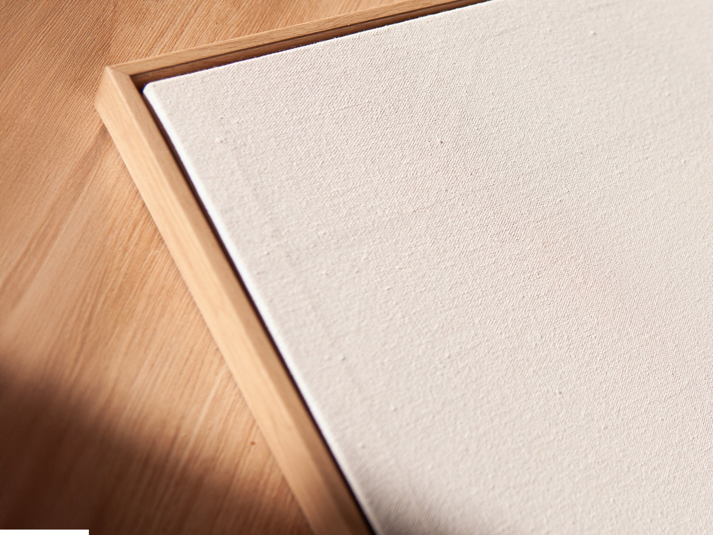 An angled close-up highlights a canvas print in a floating frame. The floral line art features abstract botanical elements. The modern flower artwork adds a touch of elegance to any room. Perfect for minimalist art and scandi decor. Explore bedroom decor ideas.