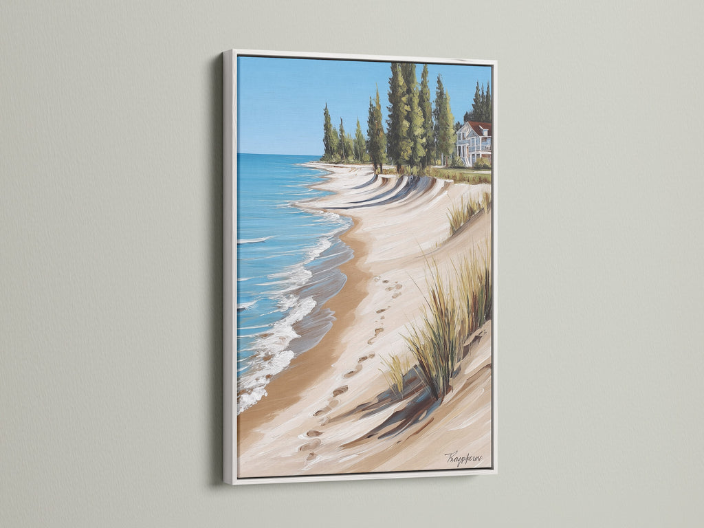 Coastal Beach House Artwork in a White Frame. This artwork features a beautiful ocean view with a sandy shoreline. Enhances any space with beachy wall decor. Great for spas and seaside boutiques seeking coastal prints.