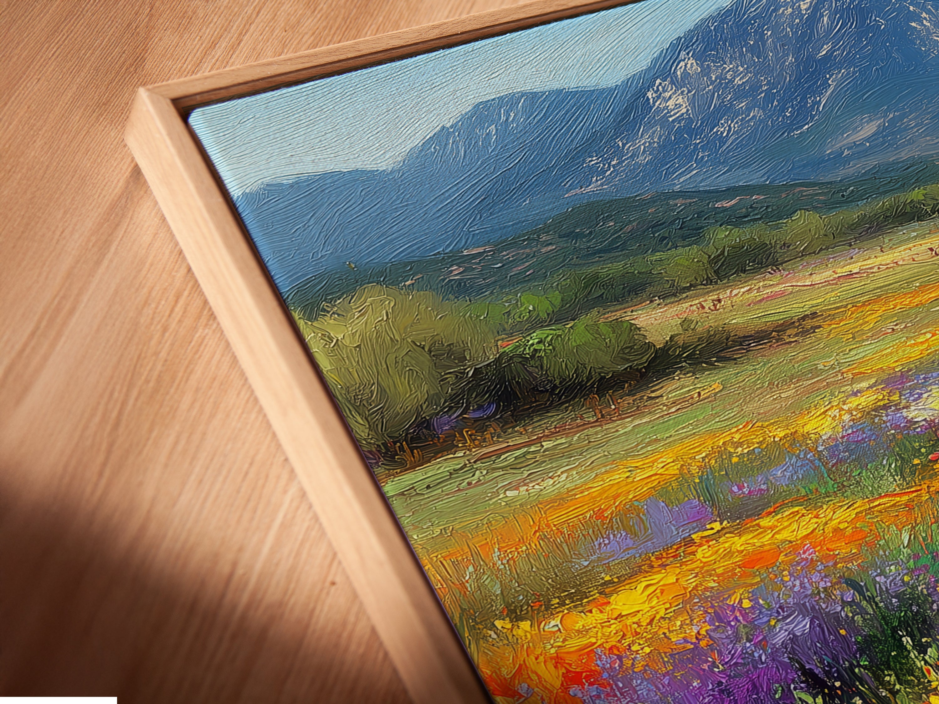 Close-up of a wildflower meadow canvas art print in a floating frame. This angled view highlights the texture and detail. The mountain landscape artwork adds depth. A unique piece for contemporary wall decor.