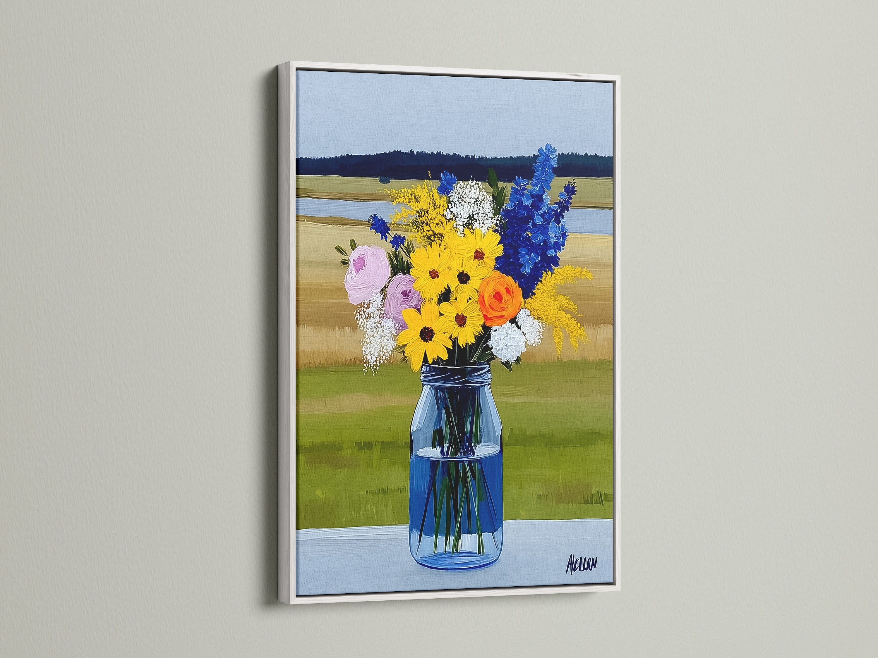 A wildflower bouquet artwork is displayed in a white frame. The art features yellow blue and white flowers in a blue vase. This artwork brings a touch of country charm. A perfect farmhouse decor piece.