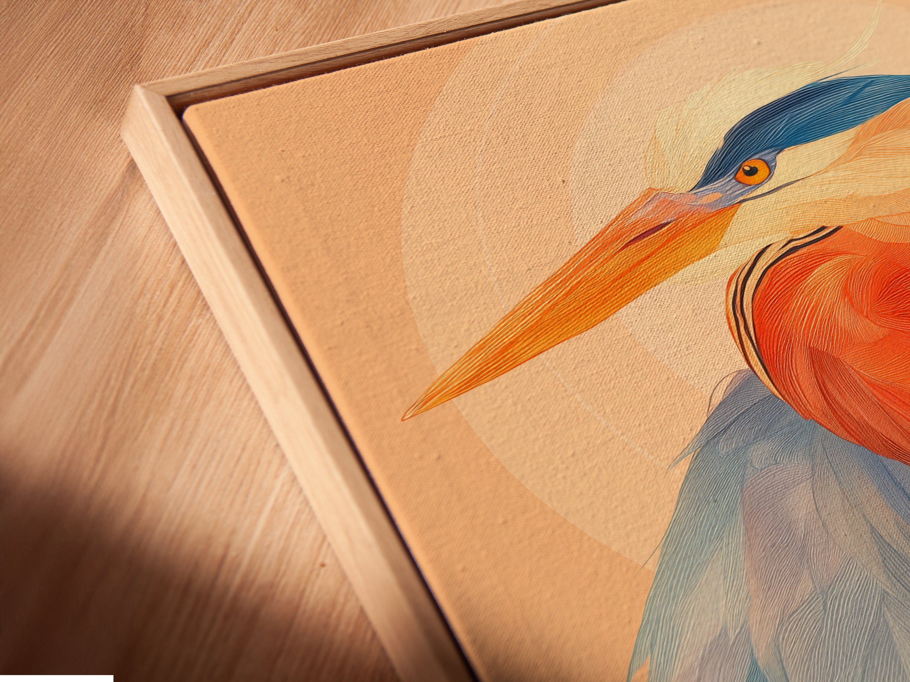 Angled close up of a canvas print in a floating frame. The heron artwork is displayed in a modern coastal setting. The blue and orange hues of the bird canvas print add vibrancy to any room. The floating frame enhances the modern art print. Perfect for adding a nature inspired touch to your office wall decor.