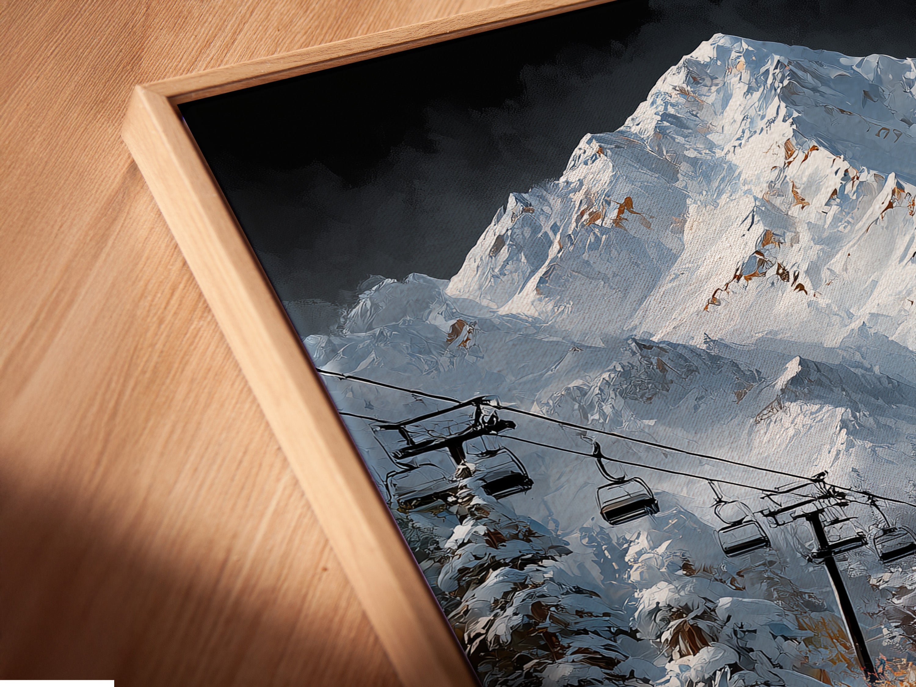 Close-up of a canvas print in a floating frame. The artwork shows a mountain village with a ski lift and stream. The floating frame adds depth to the piece. Perfect for adding a modern touch to your ski lodge decor or cabin wall art.