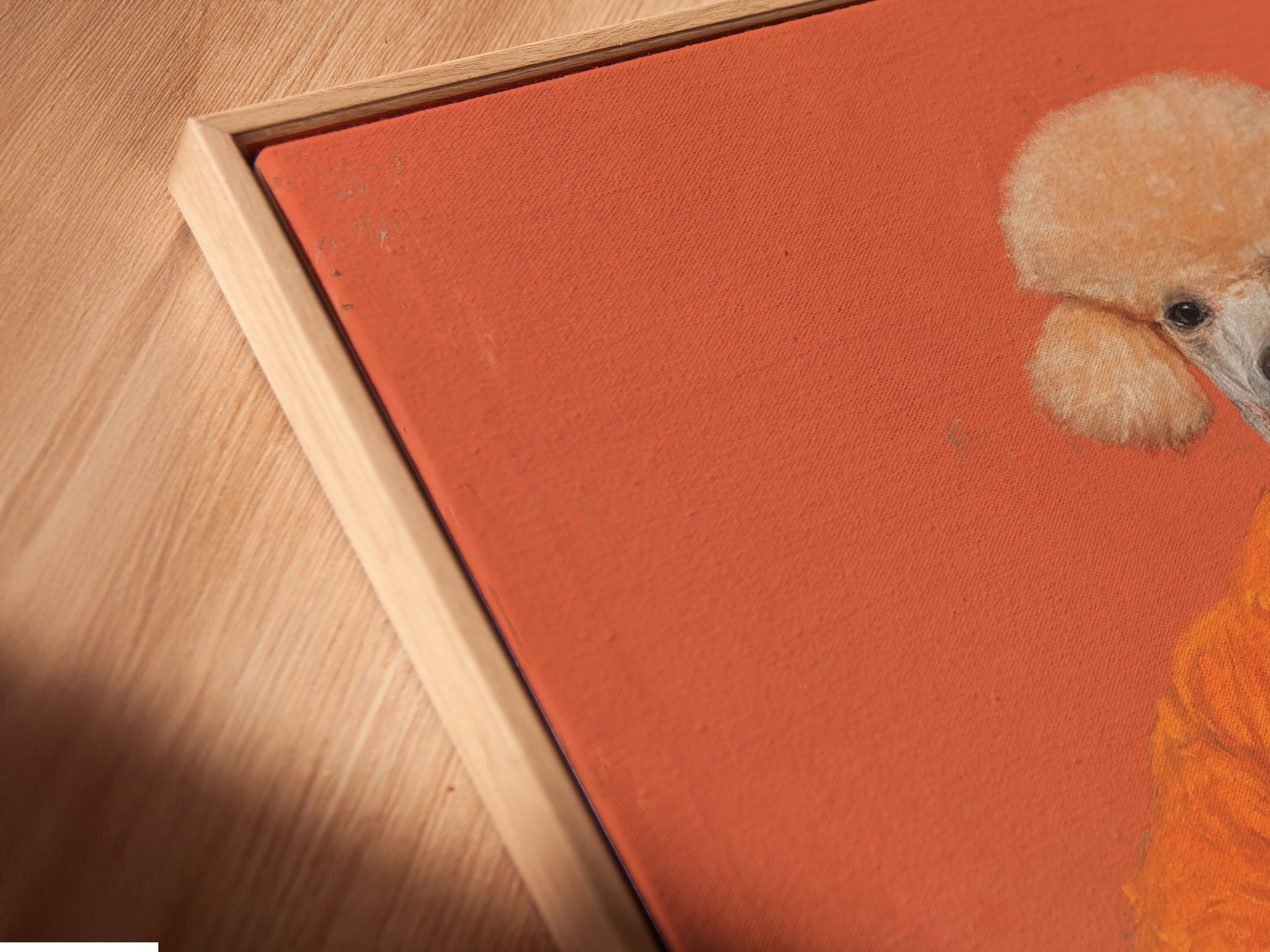 A close up angled view of a Poodle Portrait Canvas Print in floating frame. This quirky animal wall art features surreal pet art perfect for home or office decor. The primary color is orange and the secondary color is blue.