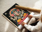 A woman is carefully rolling a fine art poster paper. This ensures safe transport and preserves the artwork. The spiritual meditation poster is ready for framing. High-quality materials guarantee a lasting piece. Perfect for home or studio.