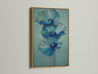 A stunning blue flower artwork is displayed in a gold frame. This floral canvas print adds a touch of luxury to your decor. Browse our selection of modern art prints. Perfect for bedroom wall decor and scandi decor.