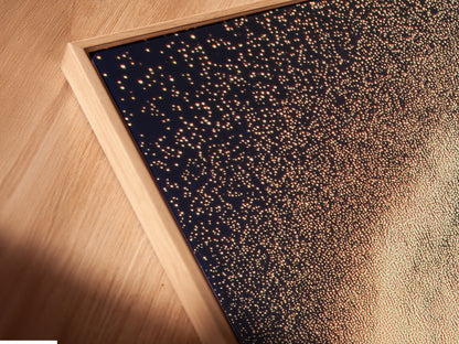 Close-up of a celestial canvas print in a floating frame. The abstract family artwork adds a modern touch to any room. The cosmic sparkle poster is perfect for kids room wall decor. This dreamy wall art enhances studios lobbies and clinics. Elevate your space with this elegant framed artwork.