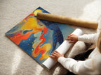A woman carefully rolling a fine art poster paper. The high-quality paper ensures the geometric ocean wall art will be preserved in pristine condition. The fine art poster captures the colorful celestial canvas print in exquisite detail.