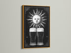 Vintage sun illustration artwork. The art print is framed in gold. The artwork features two beer glasses beneath the sun. Gold frames add a touch of elegance. Enhance your space with this striking piece.