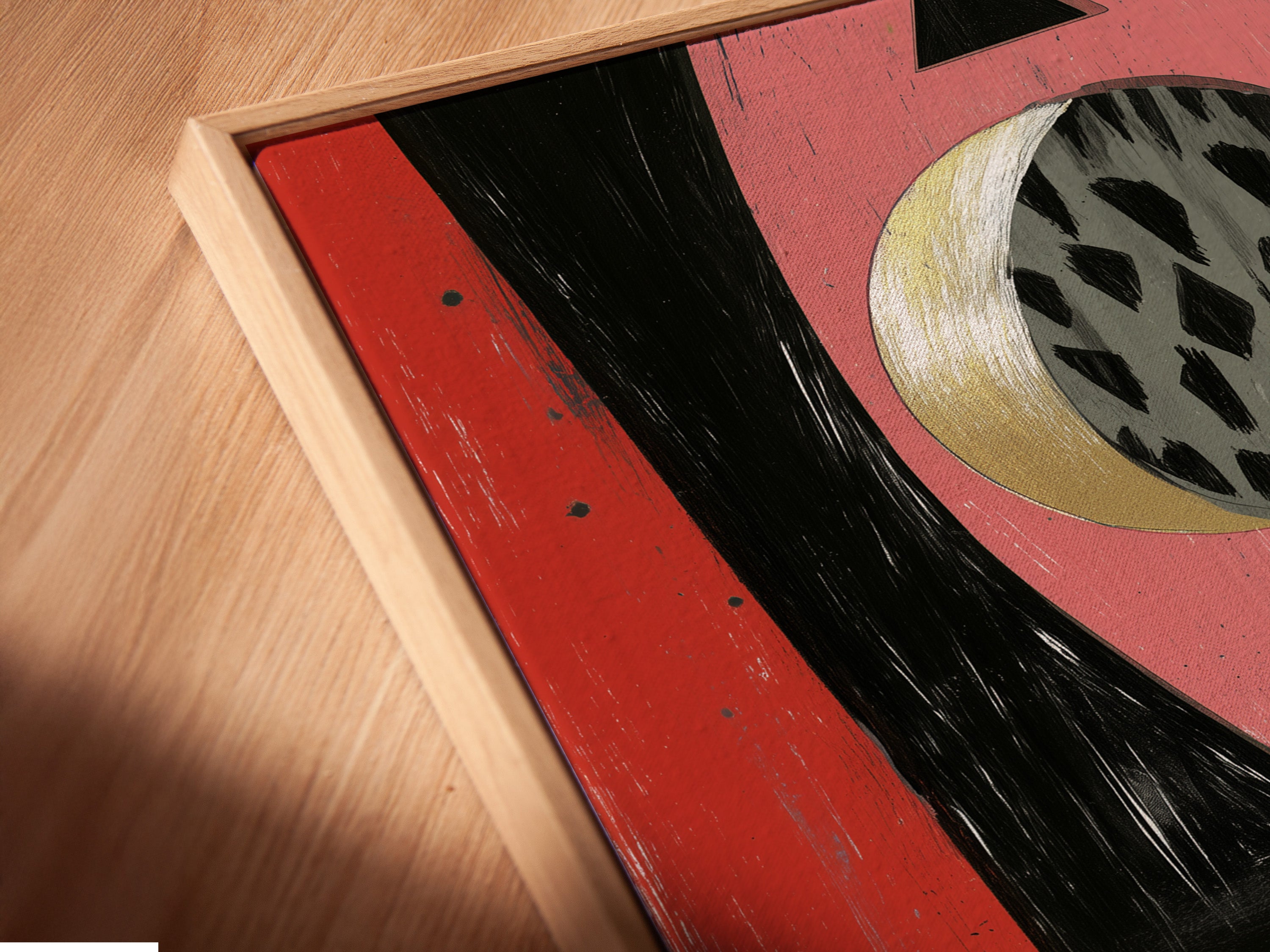 A close-up shot showcases a canvas print in a floating frame. The abstract geometric artwork features pink coral black and gold colors. This modern piece adds a contemporary touch to any room. It is ideal for boutique wall decor or coffee shop art. Elevate your space with this stunning artwork