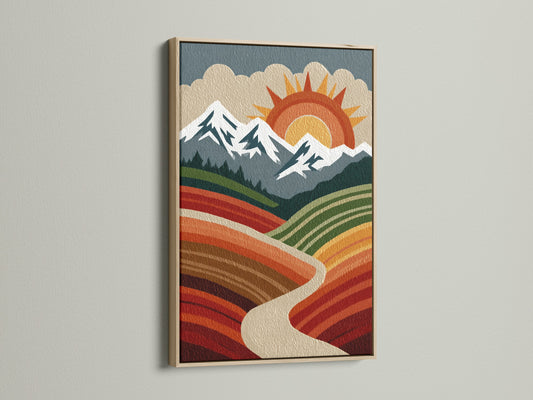 Retro boho mountain landscape art in an oak frame. The artwork depicts a sun mountains and valley. The artwork is mounted on a white wall. The oak frame enhances the vintage aesthetic perfect for eclectic decor.