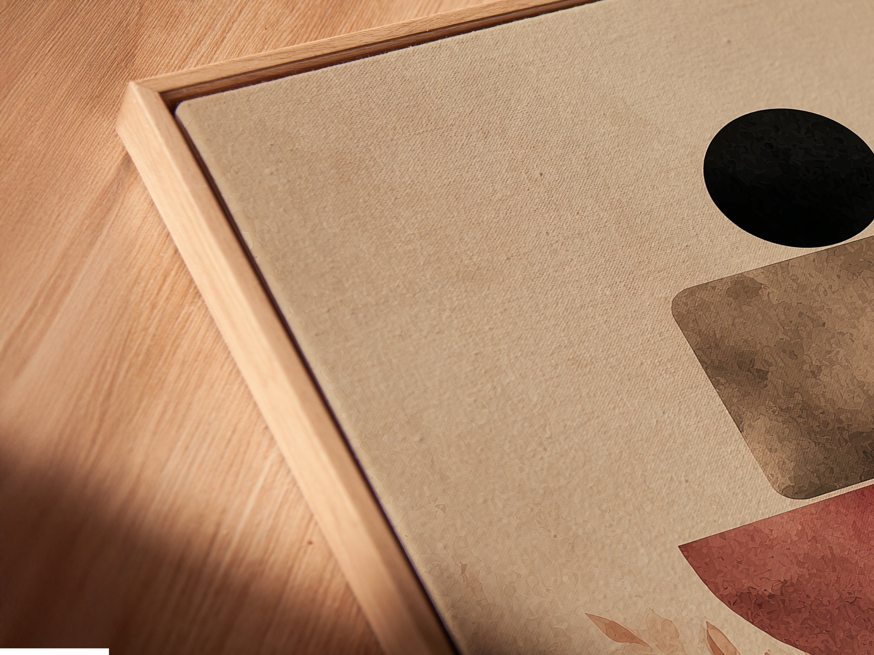A close-up angled view shows a canvas print in a floating frame. The abstract artwork features terracotta geometric shapes and neutral tones. Ideal for modern interiors it enhances minimalist and scandi themes. Perfect for living spaces and offices.