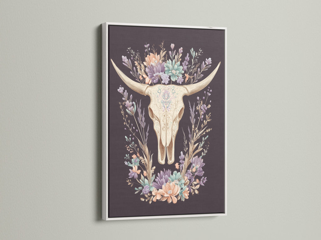 Artwork featuring a bovine skull with floral elements. It is encased in a white frame. The white frame offers a clean and modern aesthetic. It allows the artwork to stand out. The art piece is perfect for light-colored walls. Consider this art piece for a sophisticated look.