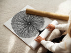 A woman is carefully rolling a fine art poster paper of the Tree of Life artwork. The poster paper ensures high-quality reproduction. This allows for easy handling and framing. It is ideal for creating custom wall art.