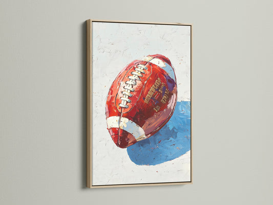 A close-up reveals a football art canvas print with an oak frame. This sports wall art brings modern Americana to any space.  Ideal for man cave decor or game room art.  The art features bold colors like red and blue. This artwork makes a thoughtful sports gift.  It's a perfect masculine decor addition.