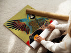 A woman is carefully rolling a fine art poster paper. This highlights the care in handling fine art. The parrot DJ artwork is available as a poster. Explore fine art poster options here for your studio.