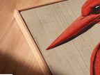 A close-up view of a canvas print in a floating frame. The red bird artwork stands out creating a visually appealing display. The floating frame enhances the artwork. It is perfect for modern home decor.