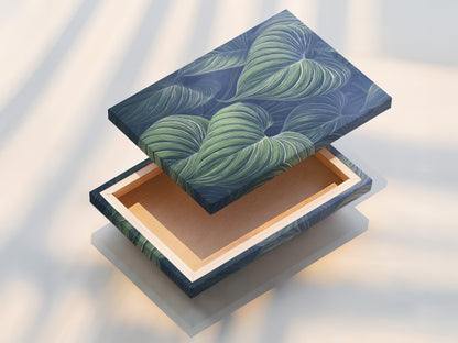 A stretched canvas print of tropical leaf art. The blue green botanical wall art is ready to hang. This canvas print is perfect for living room wall art. It’s a modern botanical piece that enhances decor.