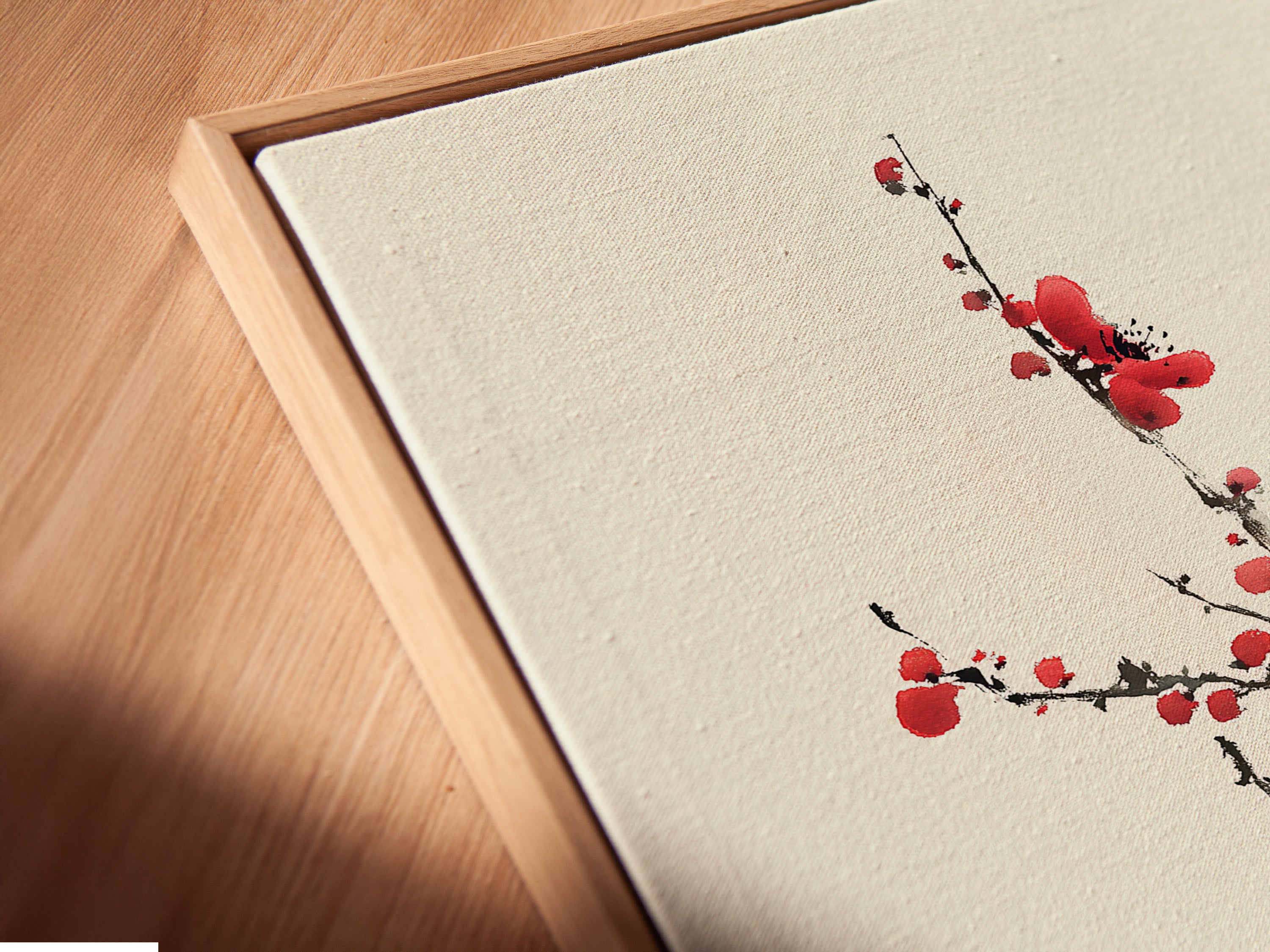 A close-up angled view of a canvas print. It is displayed in a floating frame. The floating frame gives a modern and sophisticated touch. It accentuates the artwork's depth and texture. A beautiful cherry blossom artwork is within the frame.