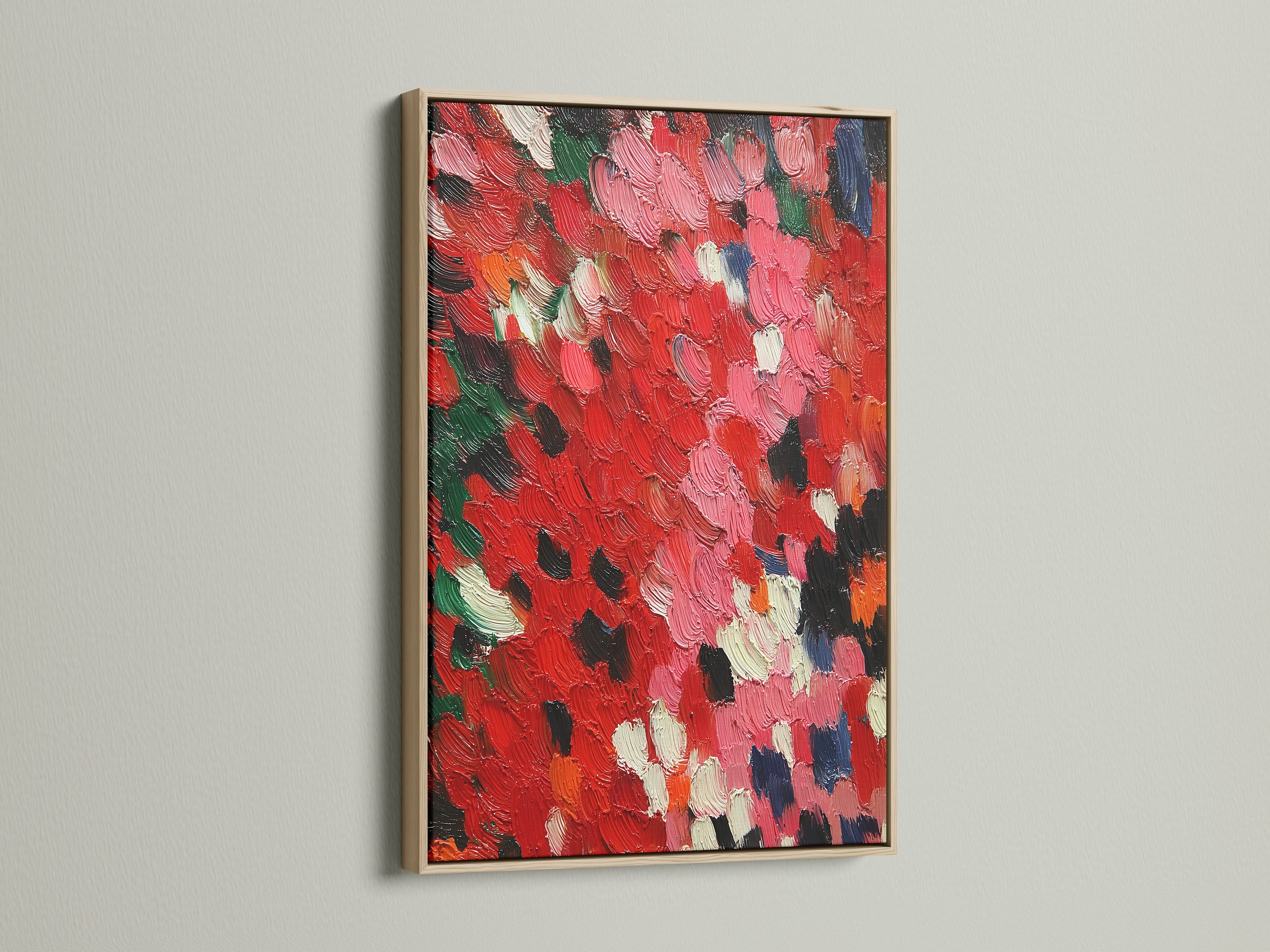 A close-up of an abstract red artwork is showcased in an oak frame. The textured canvas features an impasto painting technique. The palette knife art brings a contemporary feel to any room. This red wall art is a modern abstract piece. It is perfect for adding color and texture to your home.