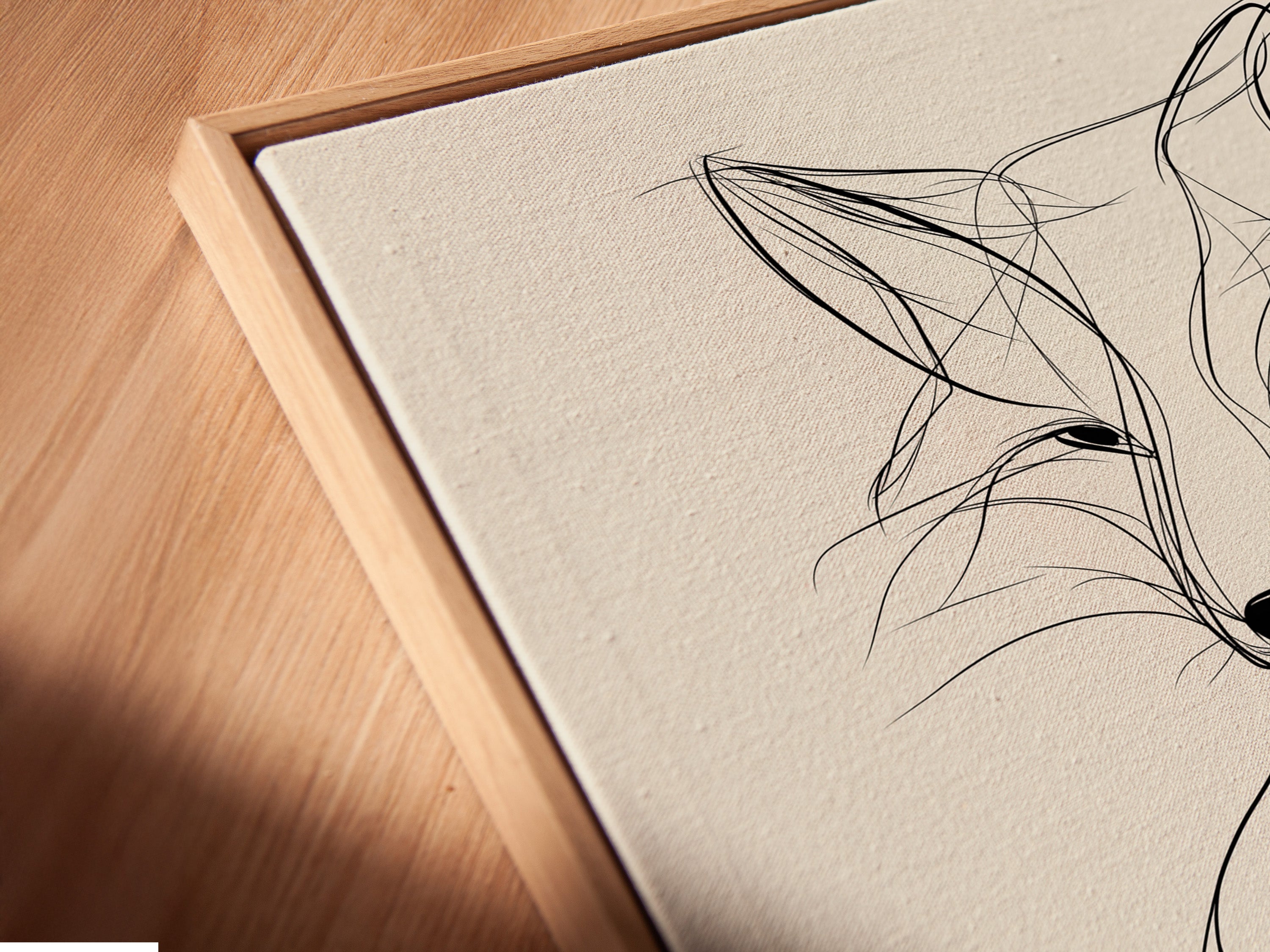 Angled close-up reveals a canvas print in a floating frame. The minimalist fox line artwork appears to float. This modern wildlife art creates a unique display. The floating frame enhances the artwork's visual appeal. It is perfect for contemporary homes and offices.