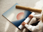 A woman rolling a fine art poster paper. The paper showcases the Sunrise Mountain artwork. This minimalist landscape print is ready for framing. Perfect for serene office decor or modern wall art.