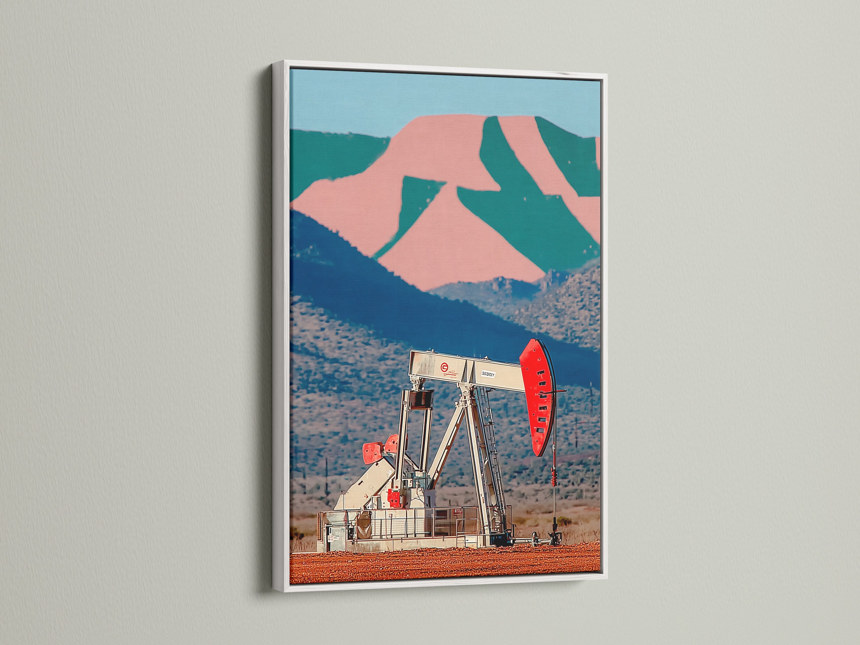 Industrial landscape wall artwork of a desert oil pump in a white frame. The retro pop art print brings color to any space. Its great for office wall decor or a vintage Americana aesthetic. The desert mountain backdrop enhances the industrial style.