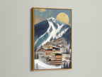 A framed Alpine Village artwork is displayed. The frame is gold. The wall art features a modern mountain ski resort. This contemporary canvas is ideal for interior decorators. It matches modern wall decor trends.