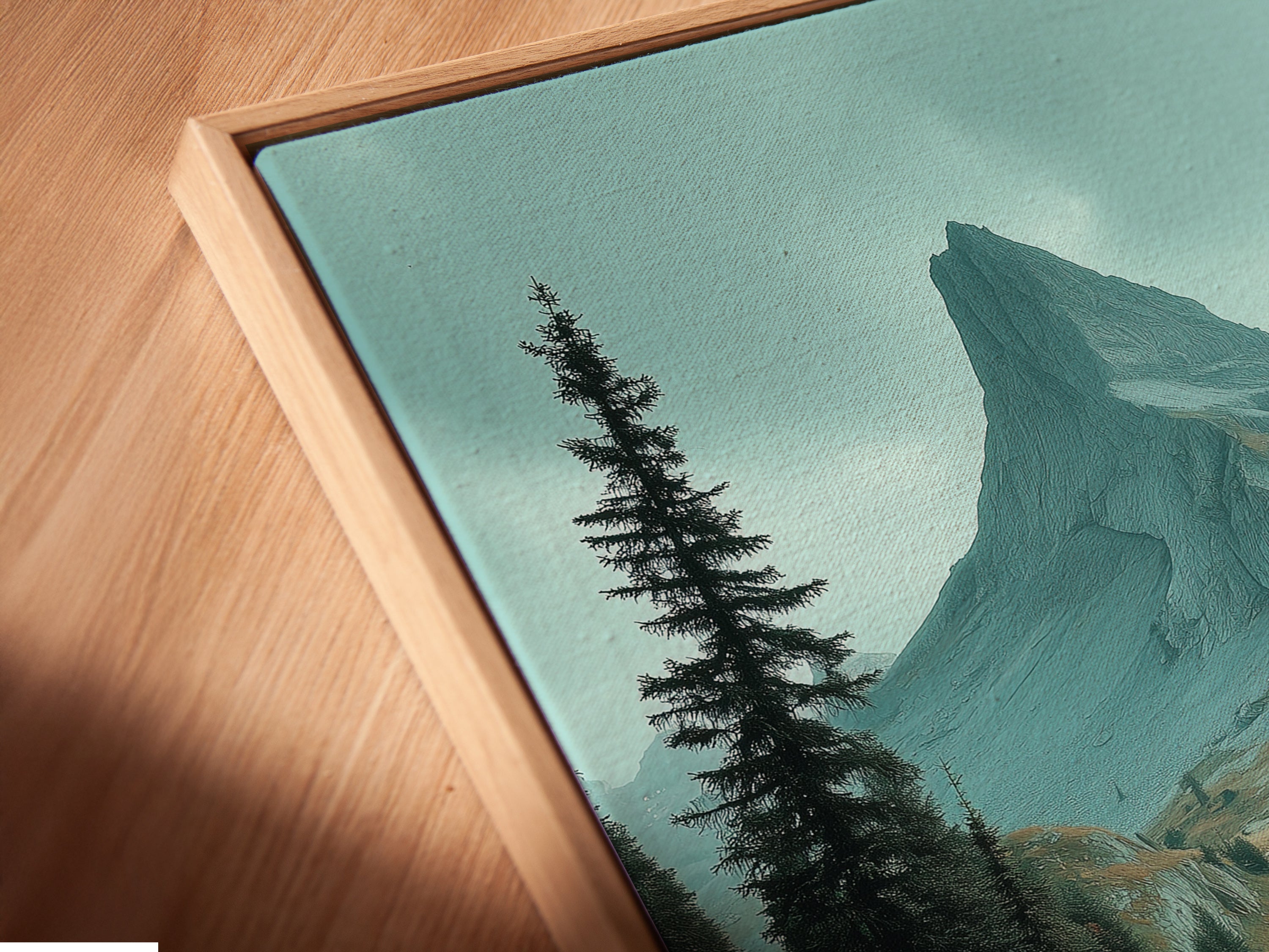 Angled close up of a canvas print in a floating frame. It features mountain landscape artwork showcasing an alpine valley. The floating frame adds a modern touch to the nature print. Perfect for creating a unique display of earth tone wall art.