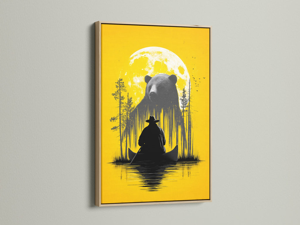 Framed Bear and Canoe artwork is displayed. The frame is an oak frame. It is a rustic nature wall art. It shows a bear and a canoe under a yellow moon. Ideal for cabin decor and adventure art lovers. The yellow decor brightens any room. Perfect for adding a touch of the outdoors to your home.