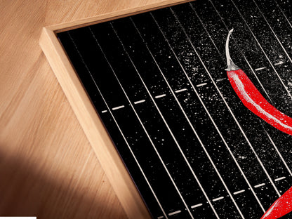 Angled close-up of a canvas print featuring chili pepper artwork in a floating frame. The modern kitchen wall art is perfect for culinary enthusiasts. The red chili print adds a spicy touch.
