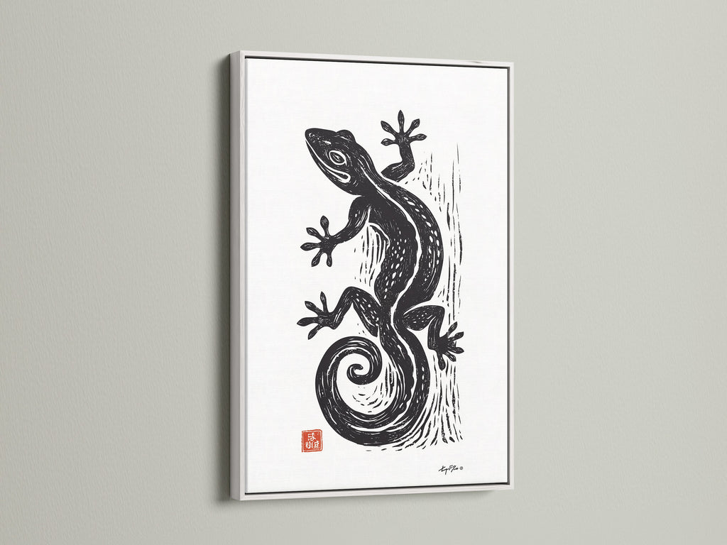 A white frame surrounds a striking art print. The black gecko artwork stands out. The white frame is clean and modern. It enhances the artwork's appeal. This framed piece is a great addition to your decor.