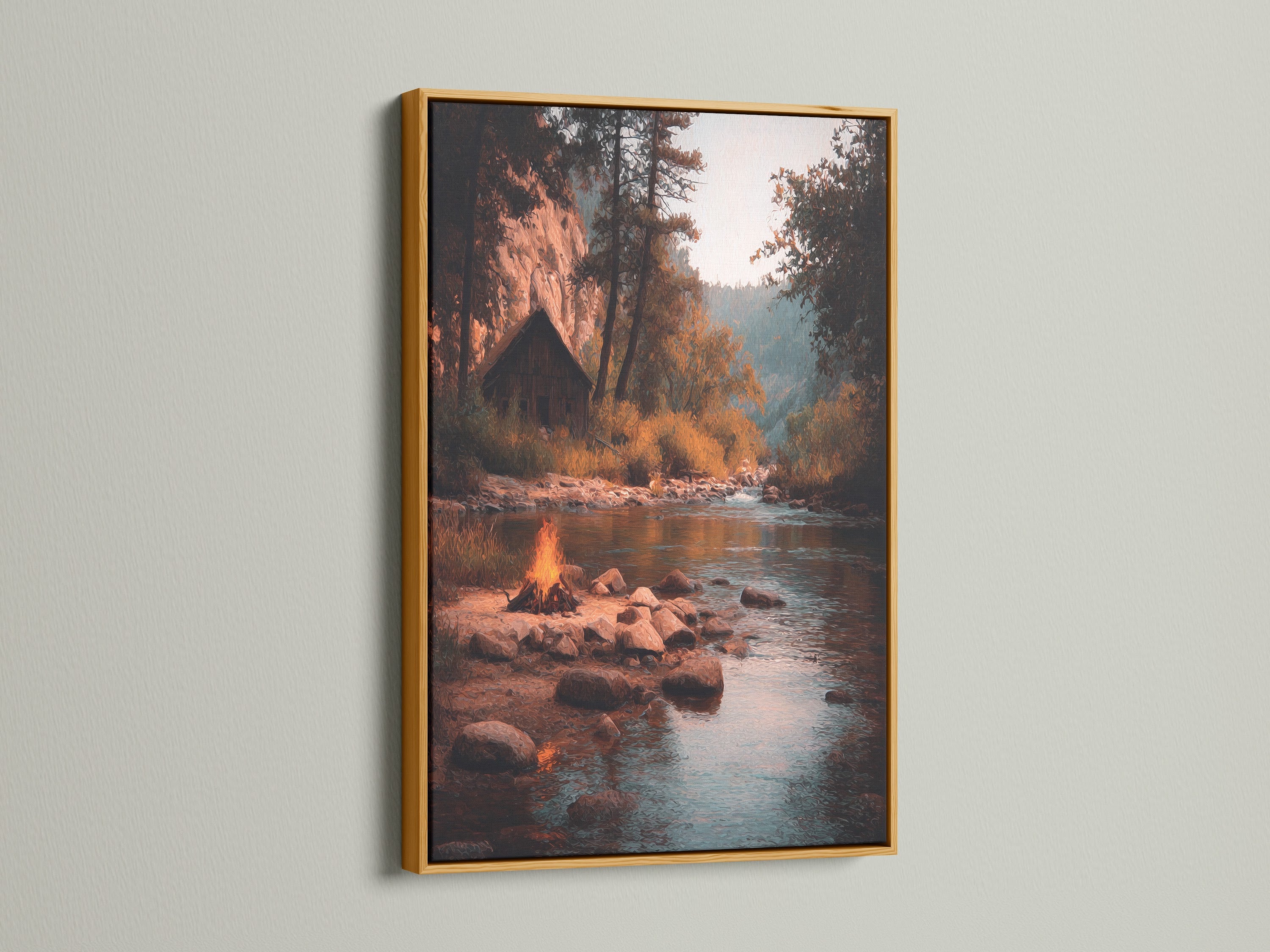 The artwork is presented in a gold frame. The artwork shows a river with campfire scene. The gold frame adds a touch of luxury. The art piece brings warmth and elegance to your home. This piece enhances any room's decor.