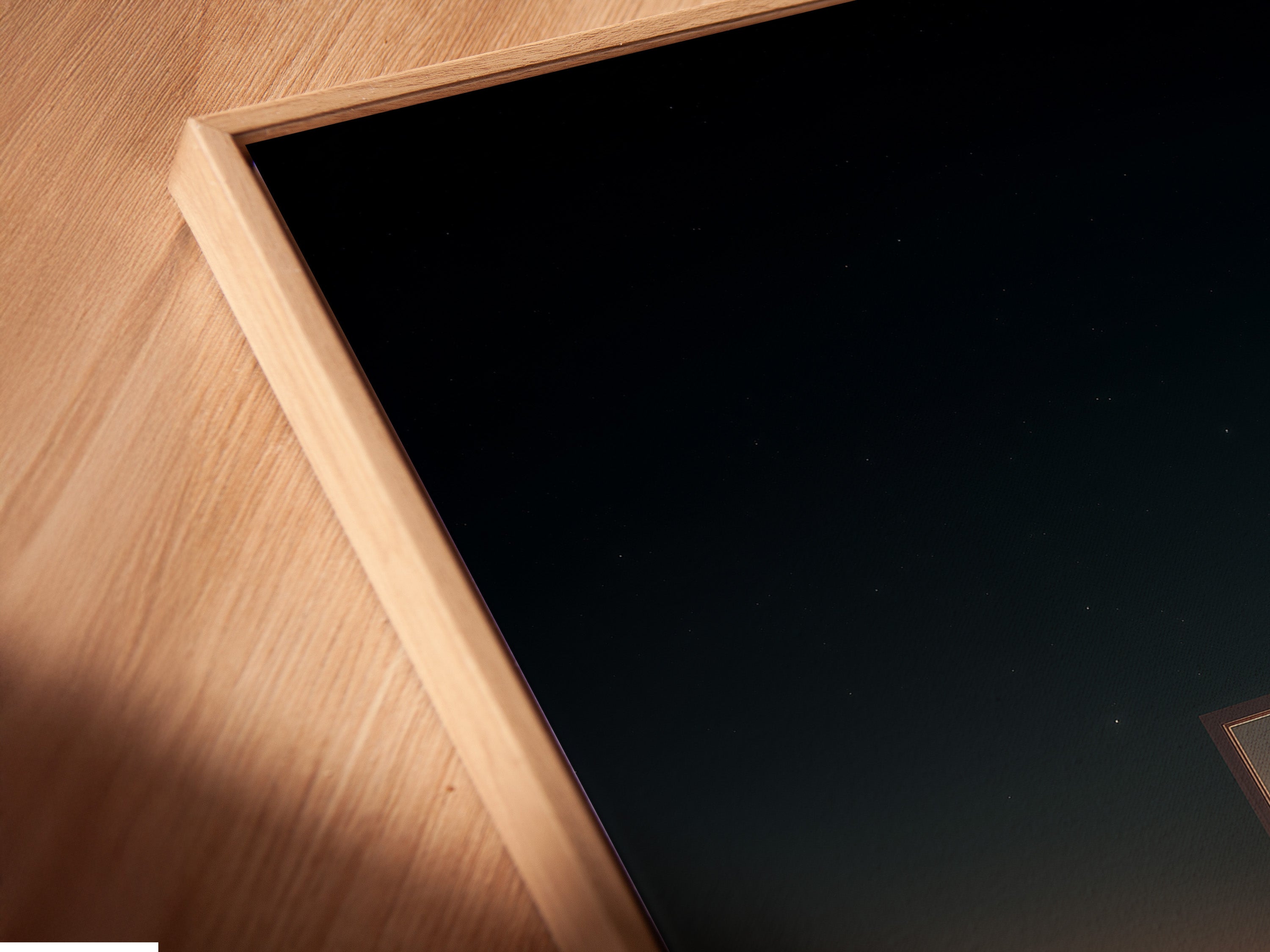 Angled close up of a canvas print in floating frame. The artwork is matted and framed. This piece would be a great addition to any home decor. The art features a door in a field.