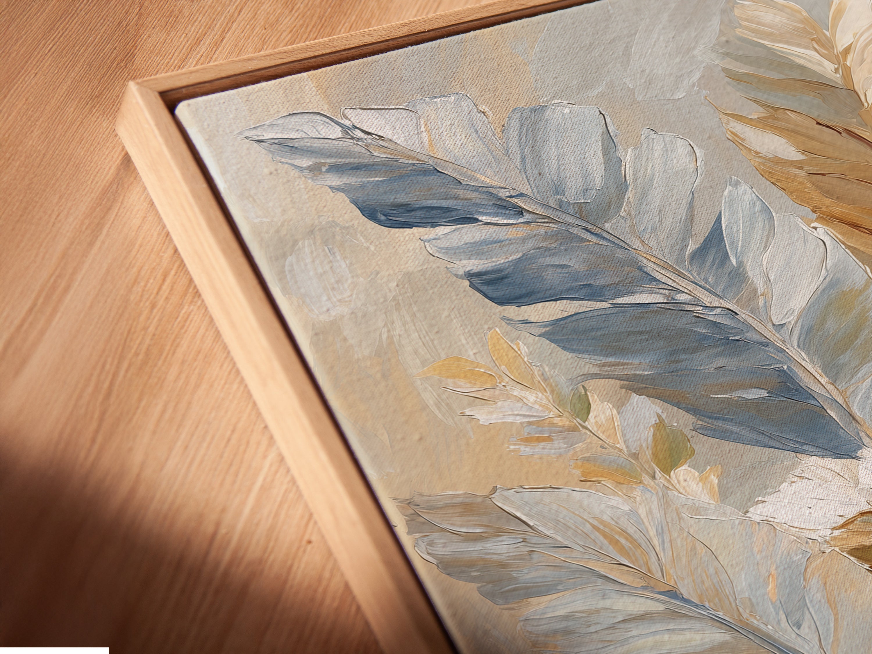 Close-up of a canvas print in a floating frame. The frame enhances the artwork's texture and depth. Feather art print with a modern gallery look. Soft neutral colors create a soothing ambiance. The floating frame adds a contemporary touch to this botanical artwork.