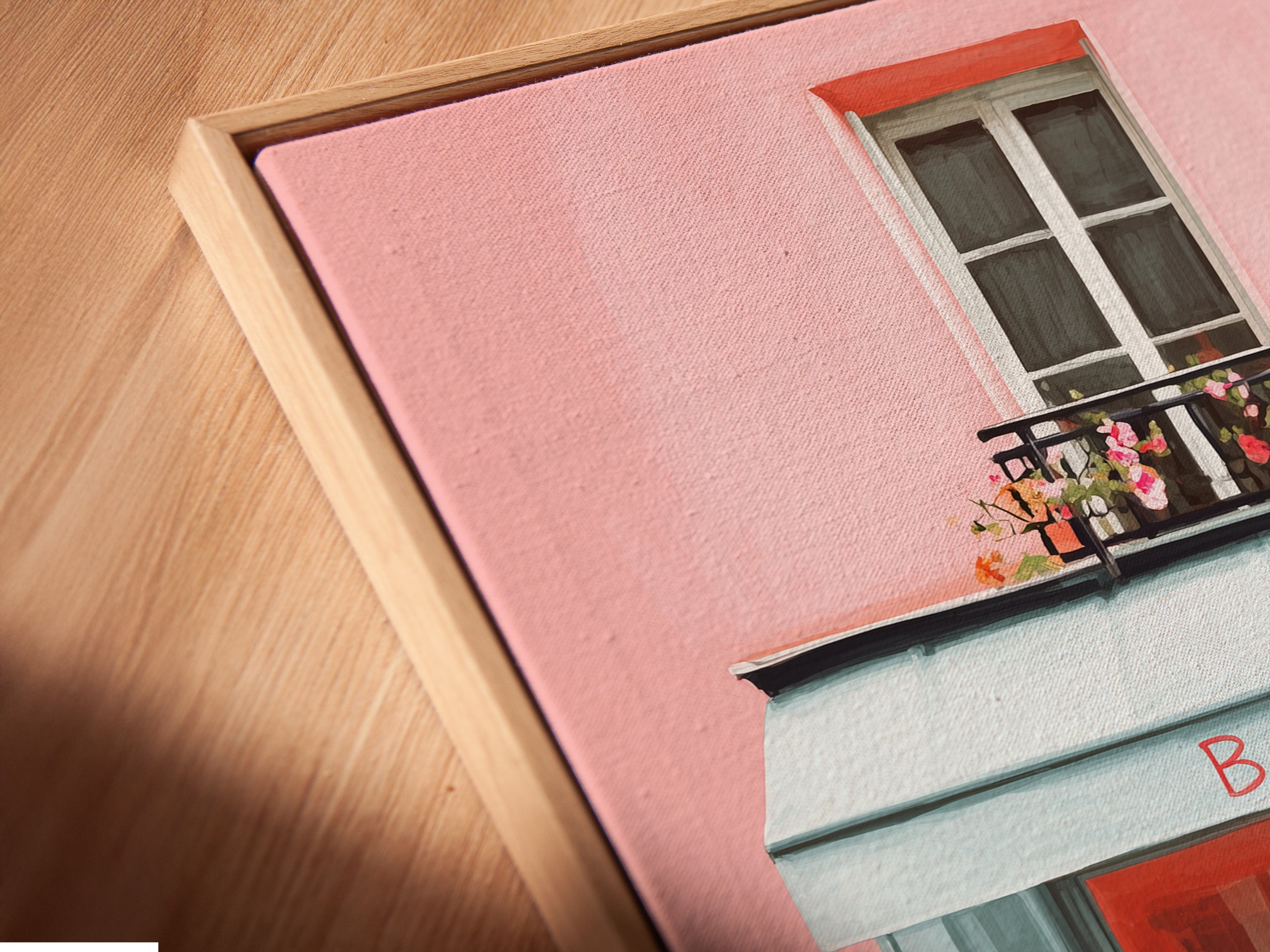 Angled close-up of a canvas print displayed in a floating frame. The artwork features a bakery with a pink exterior and blue accents. The floating frame enhances the art. It creates a modern and elegant look. This piece will add a contemporary touch to your space.
