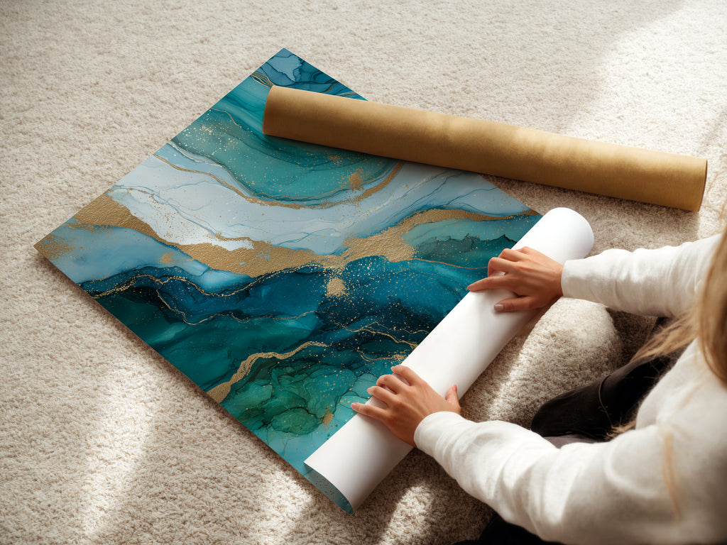 A woman is carefully rolling a fine art poster paper. The poster features the abstract ocean artwork. It has teal blue and gold accents. This fine art poster is perfect for creating custom wall art. Explore the beauty of fluid art prints.
