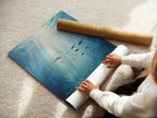 A woman carefully rolling a fine art poster paper. The paper features an underwater scene artwork. It’s perfect for creating ocean-themed wall decor. Ideal for coastal and bathroom decor projects.