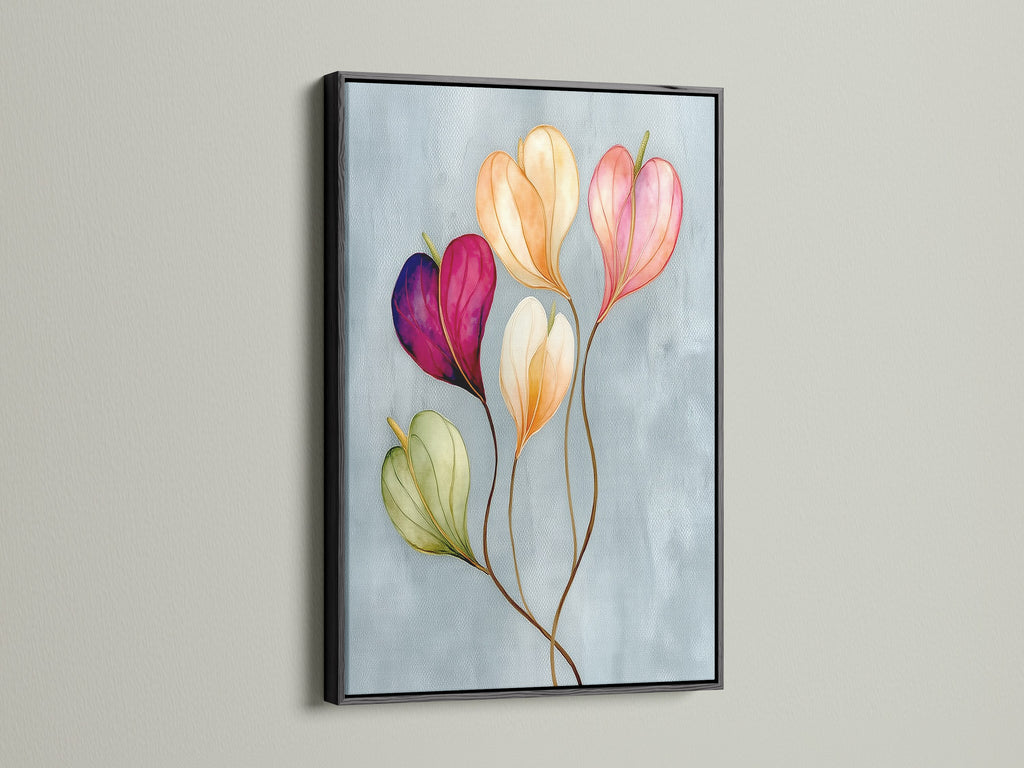 Floral watercolor canvas print in a black frame is displayed. This pastel flower art is a sophisticated touch for any room. The flower artwork brings a modern aesthetic to bedroom wall decor. It is perfect for those who love decorating with floral themes.