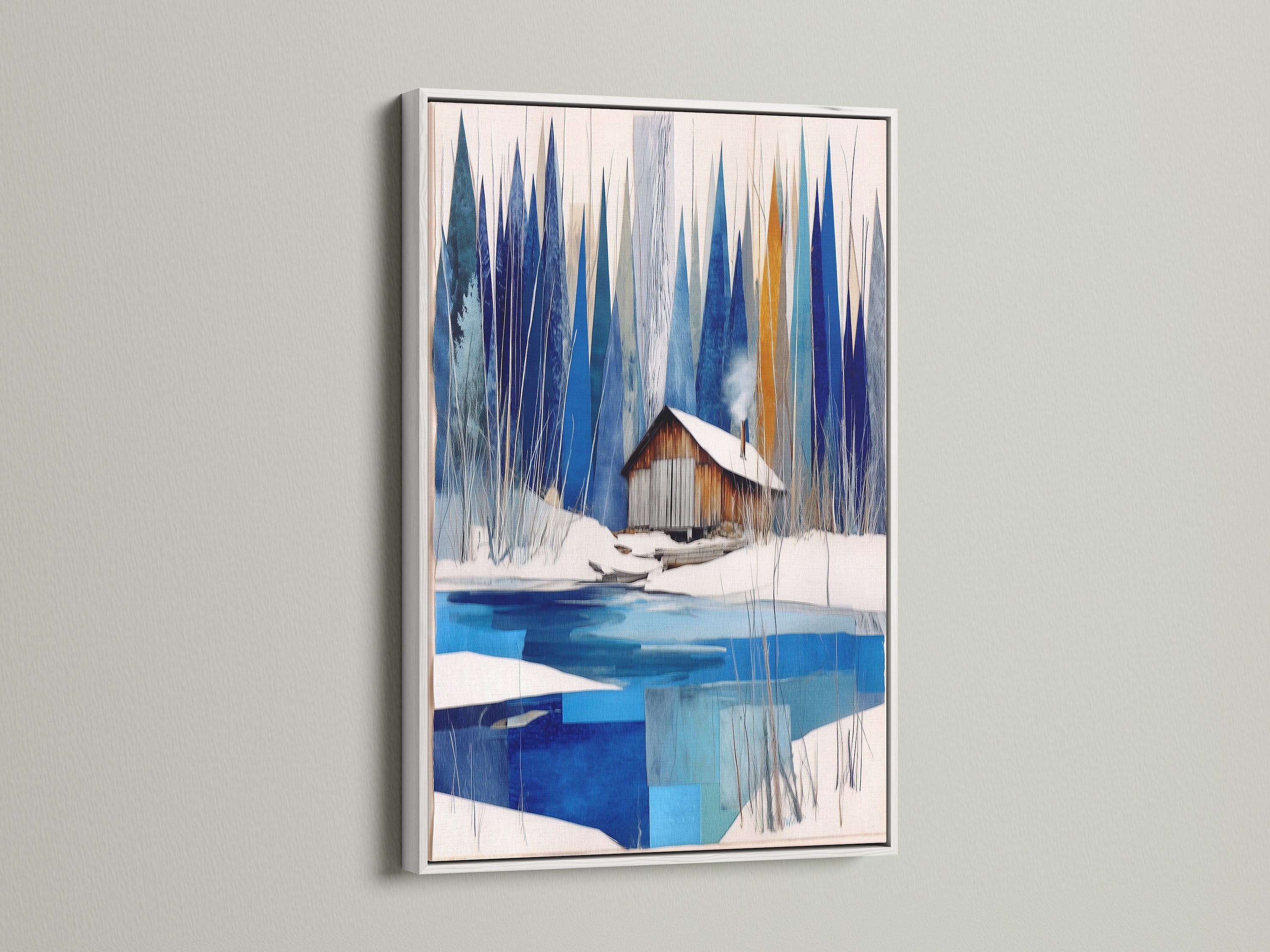 Winter Cabin Canvas Artwork with a white frame. Features snowy lake wall art for chalet decor. The white frame offers a clean crisp look to the blue and white abstract winter art. This modern wall art brightens any nature print. Ideal for lake house decor or winter cabin decor settings.