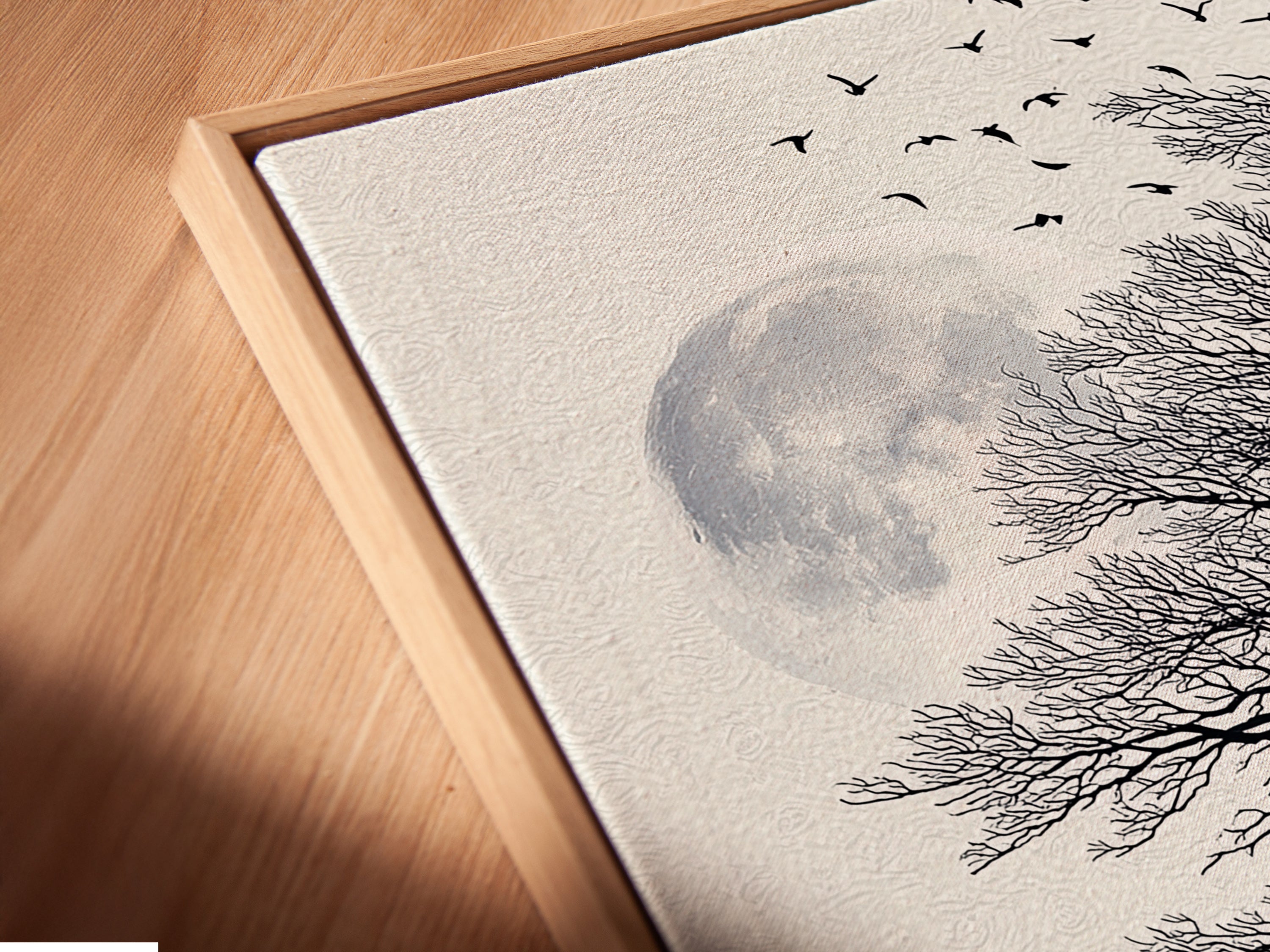 Angled close up of a canvas print in a floating frame. This wolf and moon art makes a statement. The coastal tree artwork is perfect for living rooms or offices. The frame adds a modern touch.