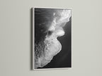 This artwork is a black and white ocean wave print. It is framed in white. It provides a clean and minimalist aesthetic. This beach canvas print brings coastal charm. It's perfect for creating a serene atmosphere. Ideal for bedroom decor and coastal retreats. Explore ocean photography with this stunning piece.