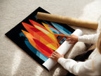 A woman is carefully rolling a fine art poster paper. The paper showcases the A-Frame house artwork. This ensures safe delivery of your coastal art print. We deliver high-quality surfboard artwork right to your door.