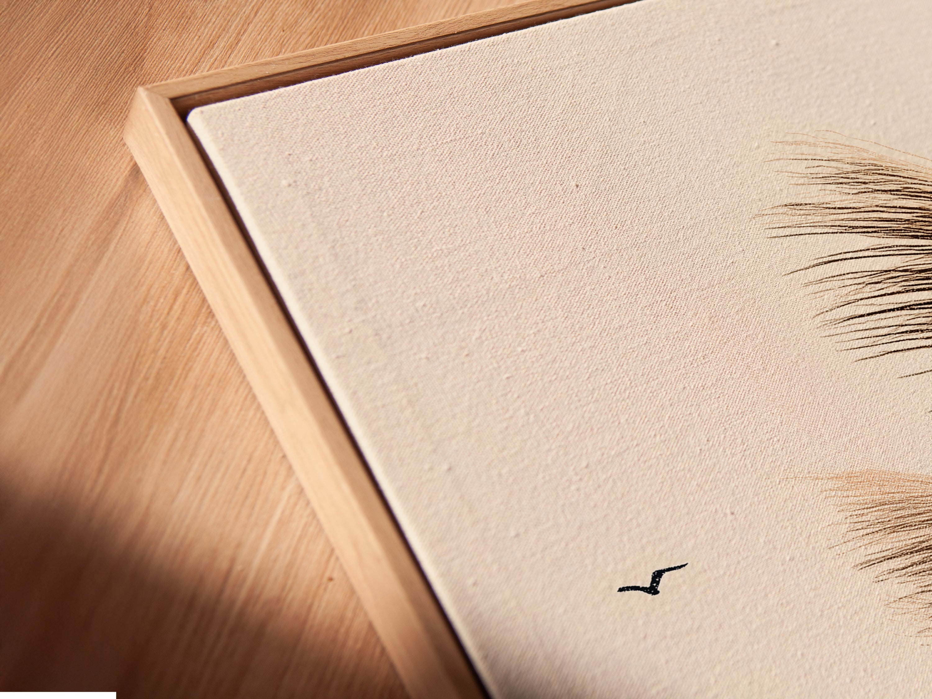 A close-up angled view of a canvas print in a floating frame. Showcasing the texture and depth of the pampas grass artwork. This minimalist print is ideal for bedroom wall decor. This is perfect for those seeking boho wall art. The floating frame adds a modern touch to the nature artwork.