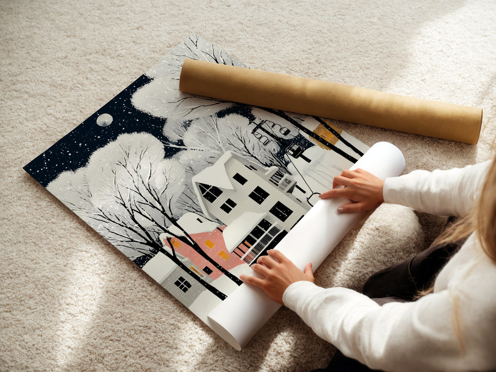 A woman carefully rolls a fine art poster paper of Winter Village art. This snowy night art is perfect for adding a Scandinavian touch to your decor. Bring a cozy winter landscape into your home.
