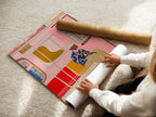 A woman is carefully rolling a fine art poster paper. The paper will be used to create a high-quality Pink Subway Art Print. This poster paper ensures vibrant colors and sharp details. It is perfect for modern urban transit and contemporary apartment decor. The paper is ideal for homeowners and renters.