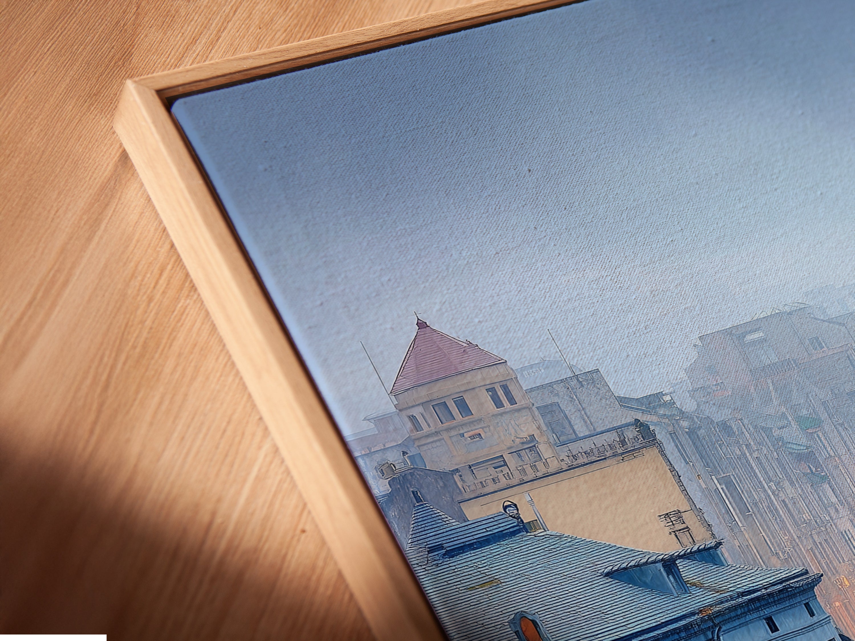 This is a close-up of a canvas print in a floating frame. The Cityscape river artwork features European architecture. It enhances office decor with misty cityscape photography. The blue wall art adds a contemporary touch.