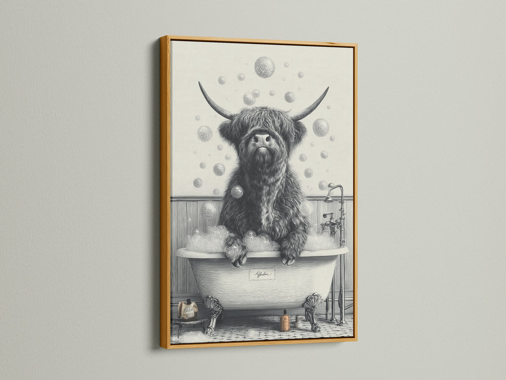The Highland Cow in Tub artwork is highlighted by a gold frame. The artwork features a black and white Scottish cow enjoying a bubble bath. This is a charming piece of animal canvas art for your farmhouse bathroom decor.